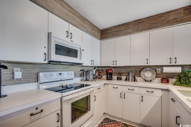 kitchen with white appliances, a textured ceiling, white cabinetry, decorative backsplash, and light countertops