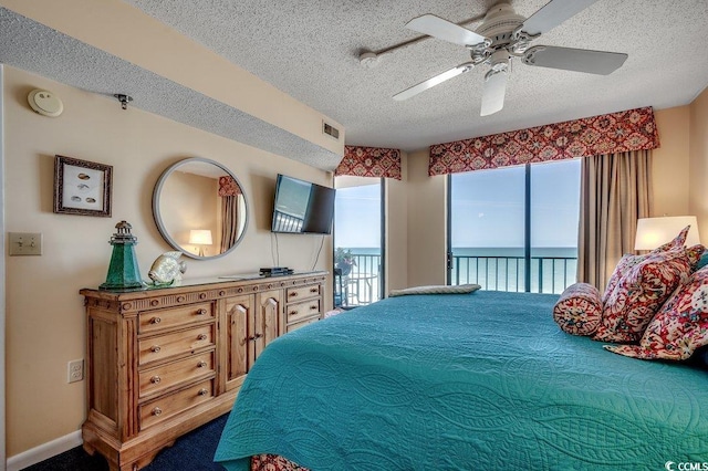bedroom with ceiling fan, a textured ceiling, access to outside, and visible vents