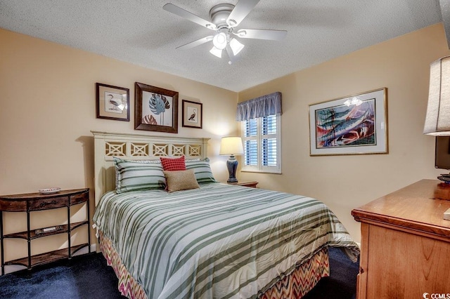 bedroom featuring a textured ceiling, carpet flooring, and a ceiling fan