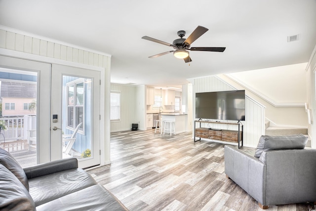 1023 S Sea Bridge Ct, Surfside Beach, SC 29575 - living room featuring ornamental molding, ceiling fan, light wood finished floors, stairs, and french doors