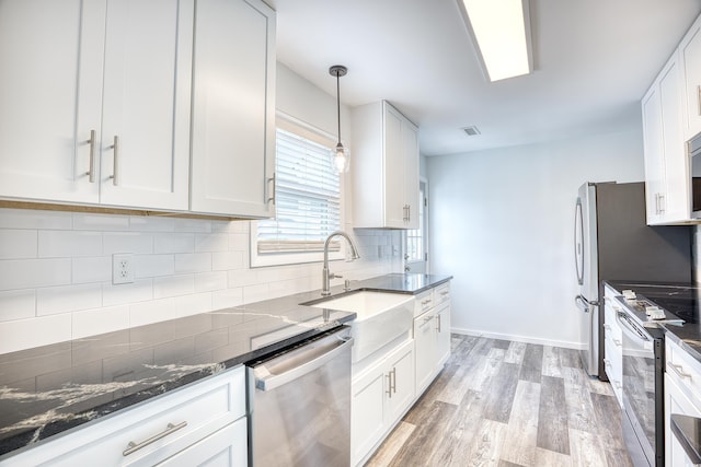 1023 S Sea Bridge Ct, Surfside Beach, SC 29575 - kitchen featuring stainless steel appliances, a sink, light wood-type flooring, and white cabinets