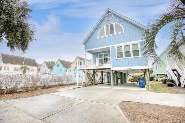 1023 S Sea Bridge Ct, Surfside Beach, SC 29575 - rear view of house with a carport, stairway, a porch, driveway, and a residential view