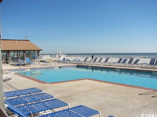 community pool featuring a water view and a patio area