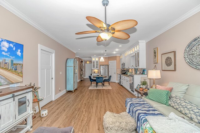 living room featuring crown molding, light wood-style floors, a ceiling fan, recessed lighting, and baseboards