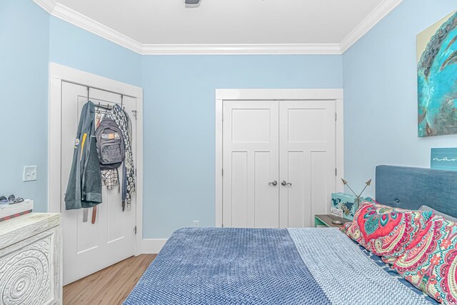 bedroom featuring ornamental molding and wood finished floors