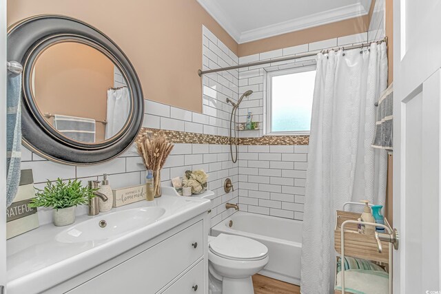full bathroom with ornamental molding, vanity, shower / bath combo, toilet, and tile walls