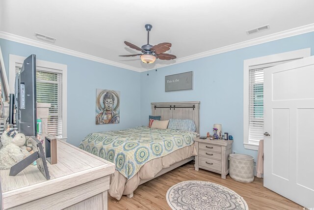 bedroom with ornamental molding, light wood-style flooring, multiple windows, and a ceiling fan