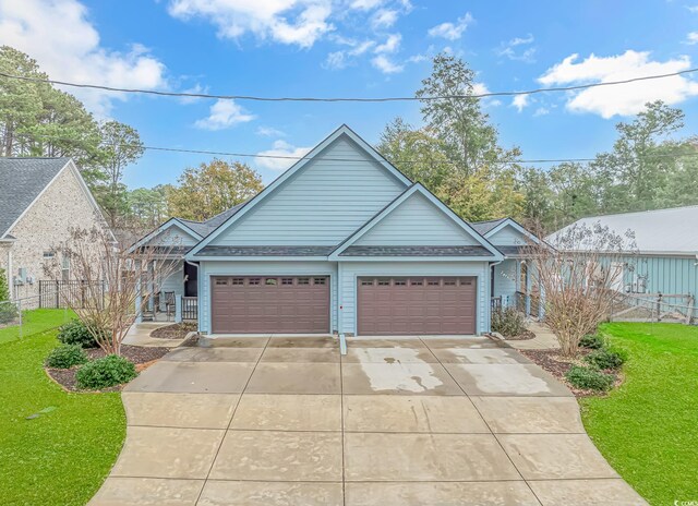 view of front of house featuring concrete driveway, a garage, and a shingled roof