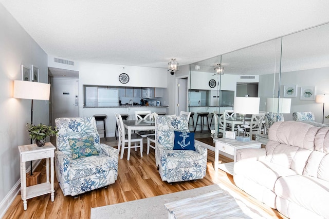 living room featuring a textured ceiling, wood finished floors, and visible vents