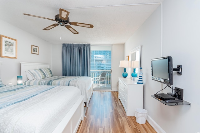 bedroom featuring ceiling fan, a textured ceiling, access to exterior, baseboards, and light wood finished floors