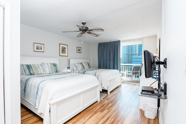 bedroom featuring floor to ceiling windows, a ceiling fan, a textured ceiling, access to exterior, and light wood finished floors
