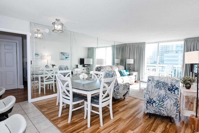dining area featuring a textured ceiling, light tile patterned floors, and a healthy amount of sunlight
