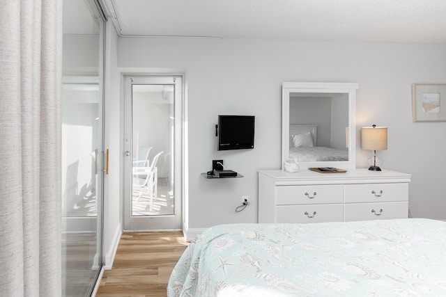 bedroom featuring light wood-style floors and baseboards