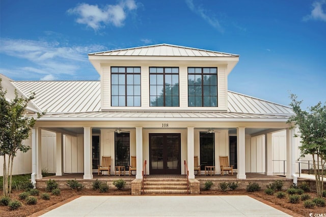 view of front facade featuring metal roof, french doors, covered porch, and a standing seam roof