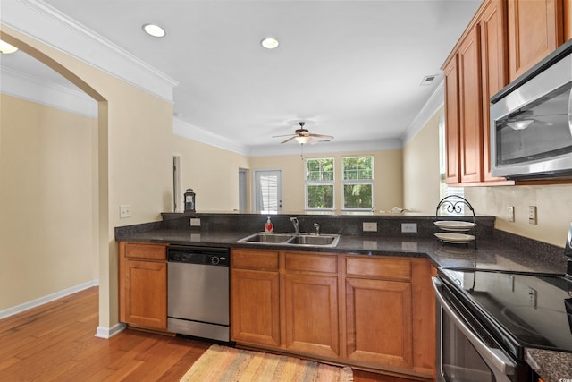 kitchen featuring a sink, crown molding, brown cabinets, and appliances with stainless steel finishes