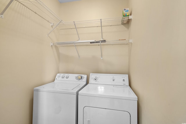 clothes washing area featuring laundry area and washer and clothes dryer