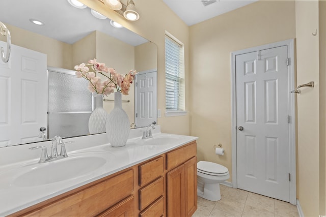 full bath with double vanity, toilet, tile patterned flooring, and a sink