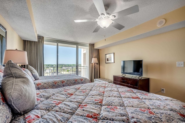 bedroom featuring a ceiling fan, a textured ceiling, and access to exterior