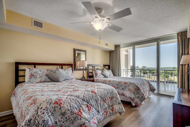 bedroom featuring a textured ceiling, visible vents, access to exterior, and wood finished floors