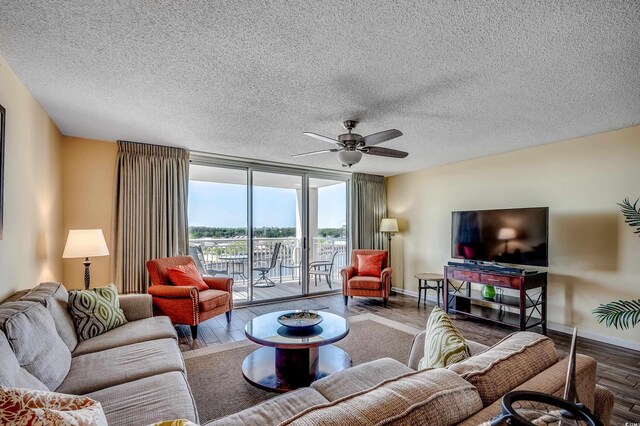 2151 Bridge View Ct Unit 2-803, North Myrtle Beach, SC 29582 - living room featuring a textured ceiling, ceiling fan, baseboards, and wood finished floors
