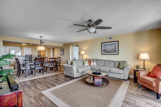 2151 Bridge View Ct Unit 2-803, North Myrtle Beach, SC 29582 - living area with visible vents, a ceiling fan, a textured ceiling, and light wood-type flooring