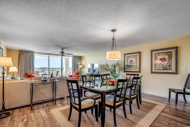 dining space featuring baseboards, a ceiling fan, a textured ceiling, and hardwood / wood-style floors