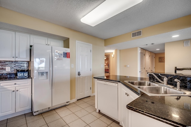 kitchen with white appliances, light tile patterned floors, white cabinets, and a sink