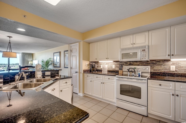 kitchen with light tile patterned flooring, white appliances, white cabinets, tasteful backsplash, and a sink