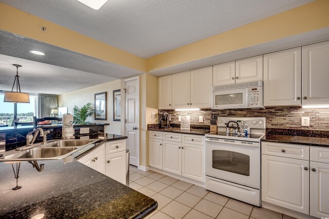 2151 Bridge View Ct Unit 2-803, North Myrtle Beach, SC 29582 - kitchen with light tile patterned flooring, white appliances, white cabinets, tasteful backsplash, and a sink