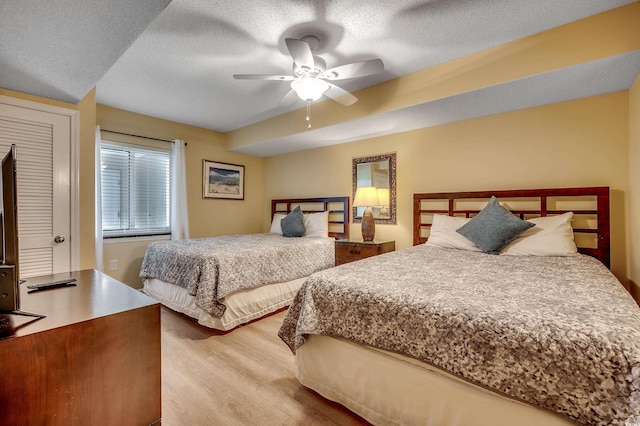 bedroom featuring a textured ceiling, ceiling fan, and wood finished floors