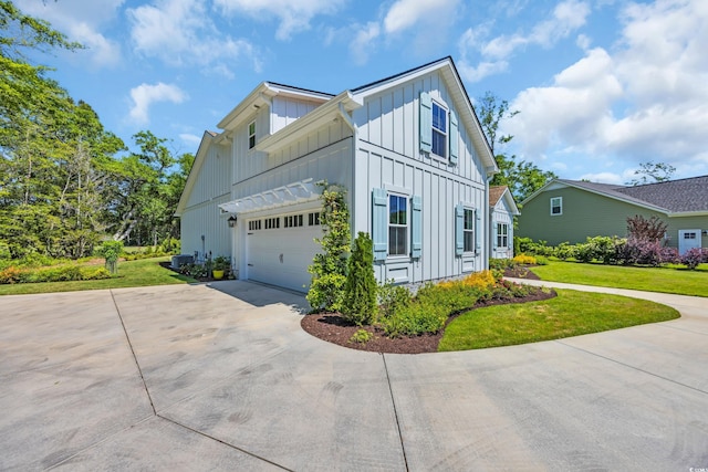 view of home's exterior featuring concrete driveway, board and batten siding, a yard, and a garage