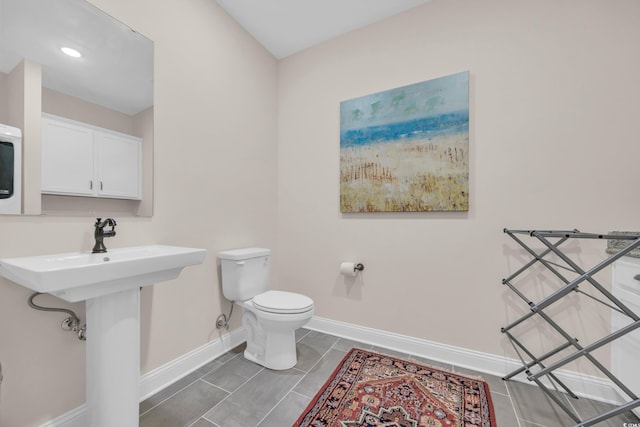 bathroom with toilet and baseboards