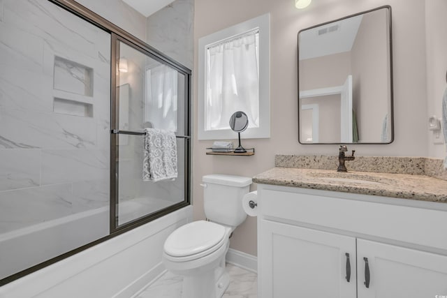 full bath with toilet, marble finish floor, vanity, bath / shower combo with glass door, and baseboards