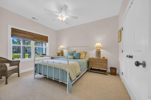 carpeted bedroom featuring visible vents, baseboards, and a ceiling fan