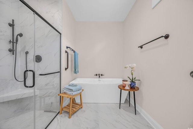 bathroom with a marble finish shower, marble finish floor, baseboards, and a freestanding tub