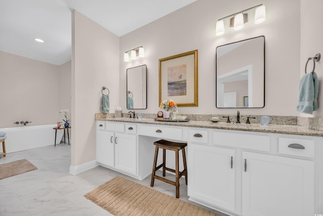 full bath featuring marble finish floor, a sink, double vanity, and a freestanding bath