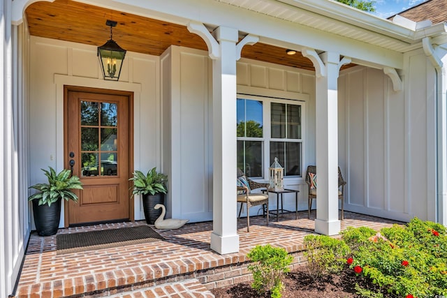 doorway to property with a porch and board and batten siding