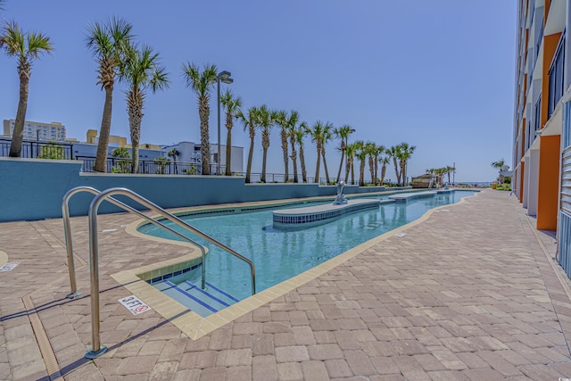 community pool with a patio and a jacuzzi
