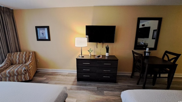 bedroom featuring wood finished floors and baseboards