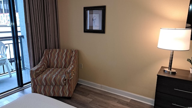 sitting room with a wealth of natural light, dark wood-type flooring, and baseboards