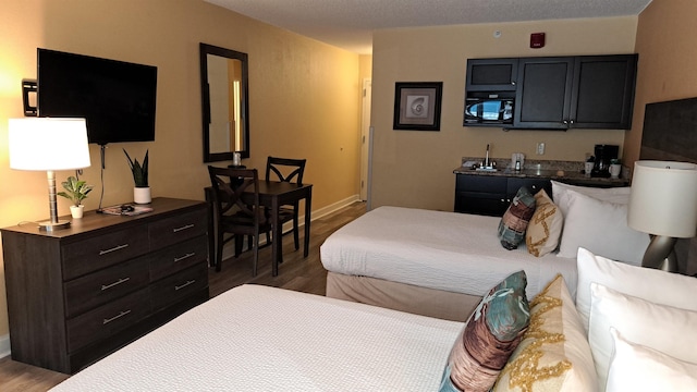 bedroom featuring baseboards and wood finished floors