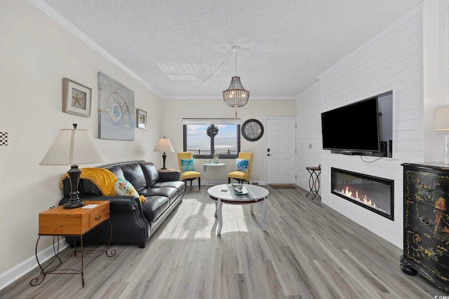 living area featuring wood finished floors, crown molding, baseboards, and a fireplace