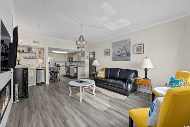 living area featuring crown molding, wood finished floors, and baseboards