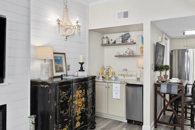 bar with light wood-style flooring, a chandelier, freestanding refrigerator, ornamental molding, and fridge