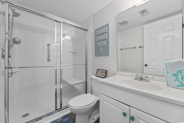 full bathroom with a textured ceiling, a stall shower, toilet, and vanity