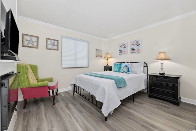 bedroom featuring crown molding, wood finished floors, and baseboards