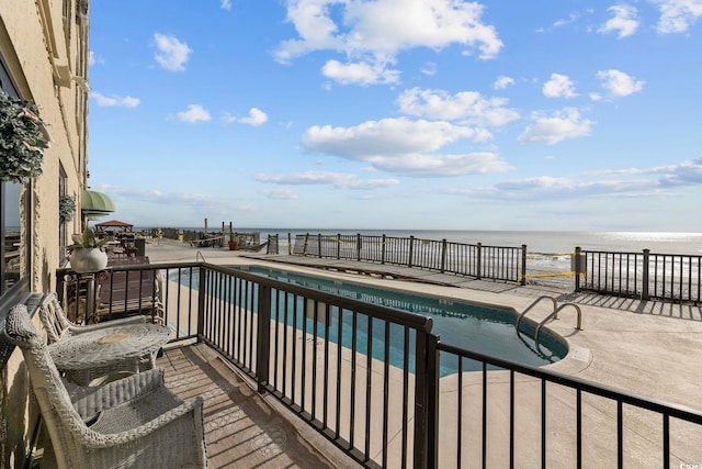 community pool with a water view and a patio