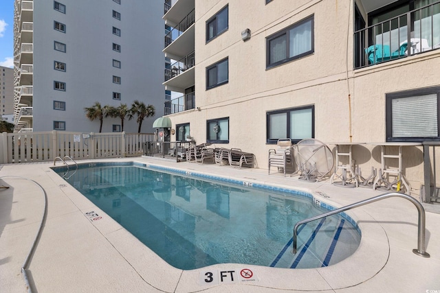 community pool with fence and a patio