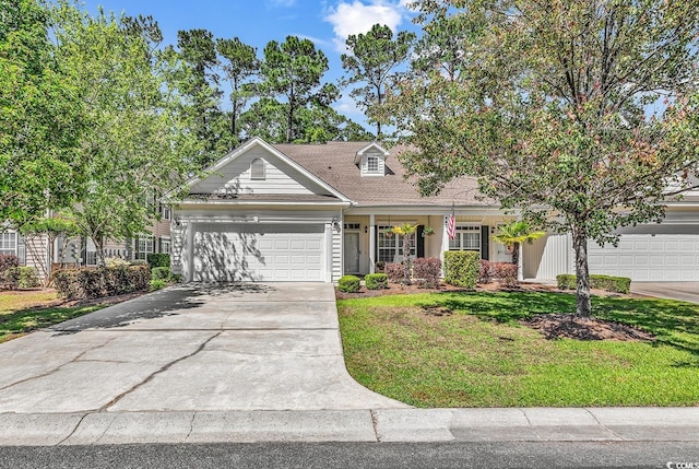 new england style home featuring a garage, a front lawn, and driveway