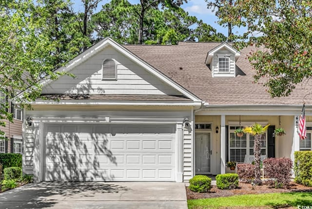 view of front of home featuring a garage, driveway, and a shingled roof